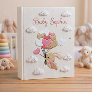 Personalized hand embroidered photo album featuring a bunny holding pastel heart balloons floating among fluffy clouds
