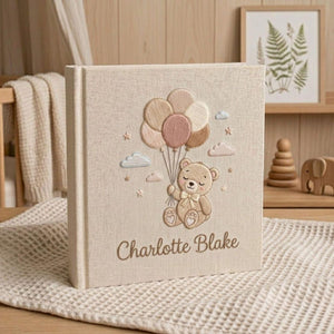 Personalized hand embroidered photo album featuring a teddy bear holding pastel balloons with custom embroidered baby name