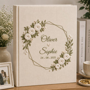 Personalized embroidered wedding photo album with white roses geometric floral wreath and custom couple names on linen cover