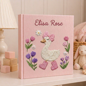 Personalized hand embroidered photo album featuring a charming goose girl with bow, flowers, and cottagecore details on a pink linen cover