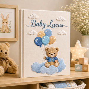 Personalized hand embroidered baby photo album with teddy bear holding blue balloons on clouds