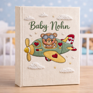 Personalized hand embroidered photo album featuring a teddy bear pilot flying a vintage airplane with clouds and stars