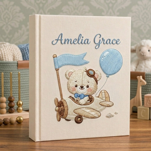Personalized hand embroidered photo album featuring a vintage aviator teddy bear flying a classic airplane with balloon and banner details