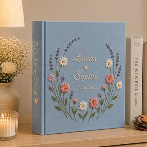 Personalized hand embroidered wedding photo album with floral wreath design, custom names and wedding date on blue linen cover