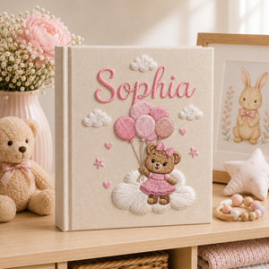Personalized hand embroidered baby photo album with teddy bear holding pink balloons on clouds