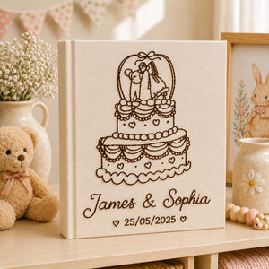 Personalized embroidered wedding photo album with tiered wedding cake embroidery, bride and groom silhouette design, custom couple names, wedding date, and elegant linen hardcover