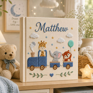 Personalized hand embroidered photo album featuring a safari animal train with giraffe, hippo, lion and zebra on a linen cover