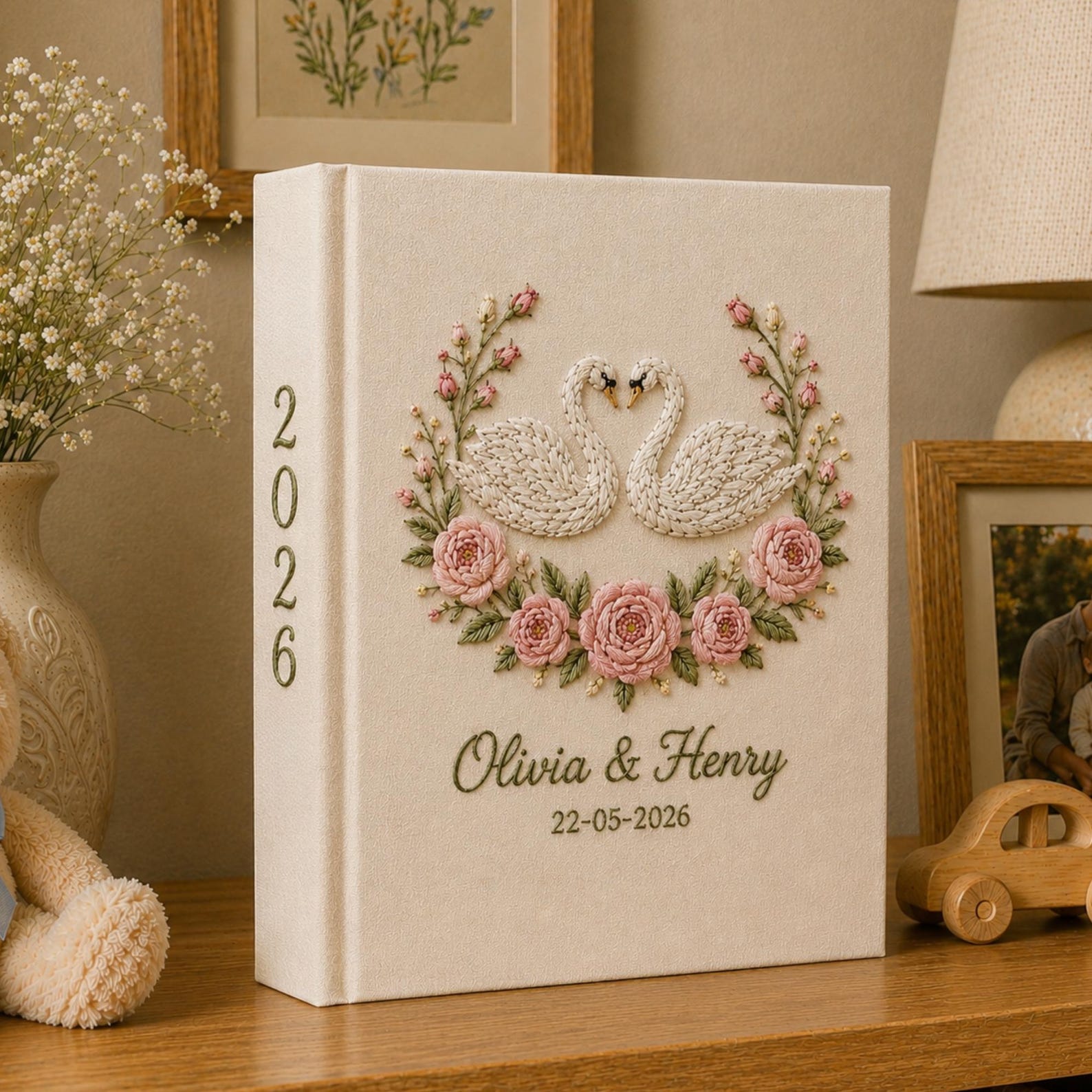 Personalized embroidered wedding photo album with white swans, blush pink rose embroidery, custom couple names, wedding date, and elegant linen hardcover design