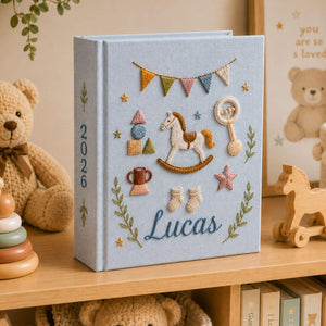 Personalized hand embroidered baby photo album with rocking horse, baby rattle, bunting flags, and vintage nursery toys