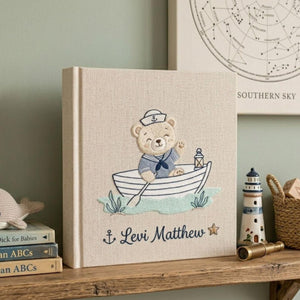 Personalized hand embroidered baby photo album with sailor teddy bear rowing a boat in a nautical nursery theme