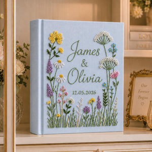 Personalized hand embroidered wild meadow wedding photo album with colorful botanical flowers and custom names on linen cover
