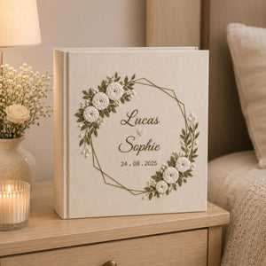 Personalized embroidered wedding photo album with white roses geometric floral wreath and custom couple names on linen cover
