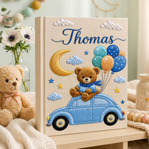 Personalized hand embroidered baby photo album featuring teddy bear on vintage blue car with balloons, moon, stars, and custom name embroidery