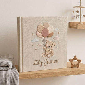 Personalized hand embroidered photo album featuring a teddy bear holding pastel balloons with custom embroidered baby name