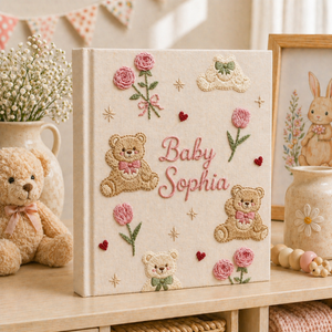 Personalized hand embroidered photo album featuring teddy bears, botanical flowers, leafy accents and custom baby name embroidery on a linen cover