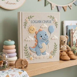 Personalized hand embroidered photo album featuring a cute blue dinosaur holding a balloon with sunshine and cloud details on a linen cover