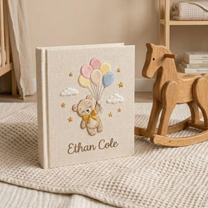 Personalized hand embroidered photo album featuring a floating teddy bear holding pastel balloons with custom baby name embroidery