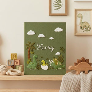 Personalized dinosaur hand embroidered baby photo album with cute prehistoric nursery design on green linen cover