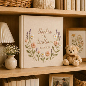 Personalized wildflower embroidered wedding album with lavender stems, pastel daisies, and custom couple names on a linen fabric cover
