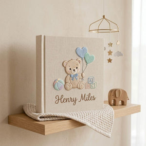 Personalized hand embroidered photo album featuring a teddy bear holding heart-shaped balloons with alphabet blocks and custom baby name