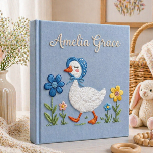 Personalized hand embroidered photo album featuring a bonnet goose walking through a whimsical storybook flower garden