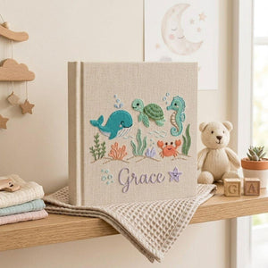 Personalized embroidered baby photo album with whale, turtle, seahorse, crab, ocean plants, and custom name embroidery