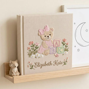 Personalized hand embroidered photo album featuring a teddy bear with pastel ABC blocks floral accents and custom name embroidery