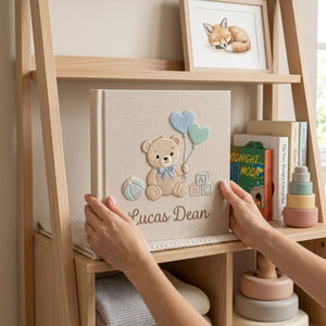 Personalized hand embroidered photo album featuring a teddy bear holding heart-shaped balloons with alphabet blocks and custom baby name