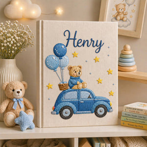 Personalized hand embroidered baby photo album featuring teddy bear riding a blue vintage car with balloons and stars on linen cover