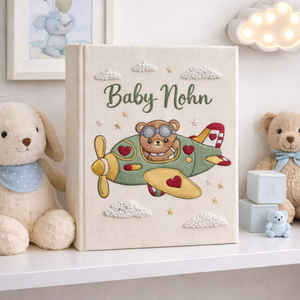 Personalized hand embroidered photo album featuring a teddy bear pilot flying a vintage airplane with clouds and stars
