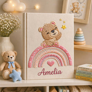 Personalized hand embroidered baby photo album featuring teddy bear sitting on pastel rainbow with stars and heart accents