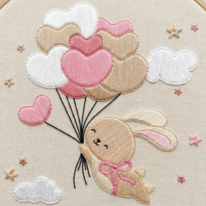 Personalized hand embroidered photo album featuring a bunny holding pastel heart balloons floating among fluffy clouds