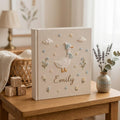 Personalized goose hand embroidered baby photo album with pastel balloons and floral meadow design on linen cover