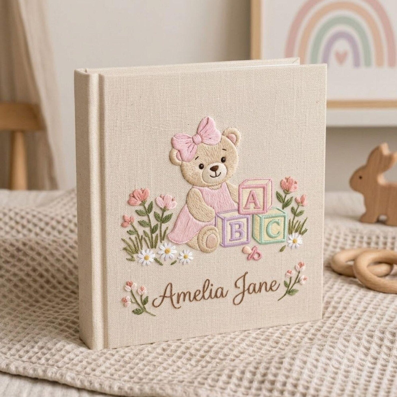 Personalized hand embroidered photo album featuring a teddy bear with pastel ABC blocks floral accents and custom name embroidery