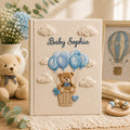 Personalized embroidered baby photo album with teddy bear in balloon basket and blue cloud nursery design