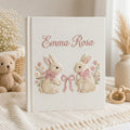 Personalized hand embroidered photo album featuring two adorable rabbits with pink bows and delicate floral accents on a linen cover