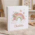 Custom embroidered baby photo album with pastel rainbow, butterflies, floral embroidery, fluffy clouds, and personalized name