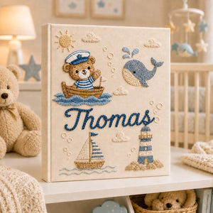 Personalized hand embroidered nautical baby photo album with sailor teddy bear, whale, sailboat, and lighthouse design