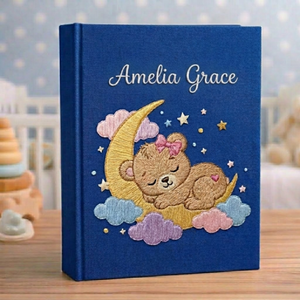 Personalized hand embroidered photo album featuring a dreamland night sky scene with crescent moon, sleeping teddy bear, stars, clouds and custom name embroidery