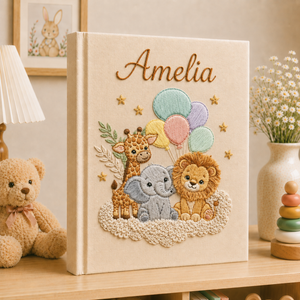 Personalized hand embroidered photo album featuring giraffe, elephant, lion, rainbow, balloons, clouds and stars on a linen cover