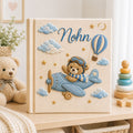 Personalized hand embroidered photo album featuring a teddy bear pilot flying a vintage airplane with hot air balloons, clouds and stars