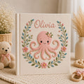 Personalized hand embroidered photo album featuring a cute pink octopus surrounded by floral wreath embroidery and pastel botanical details