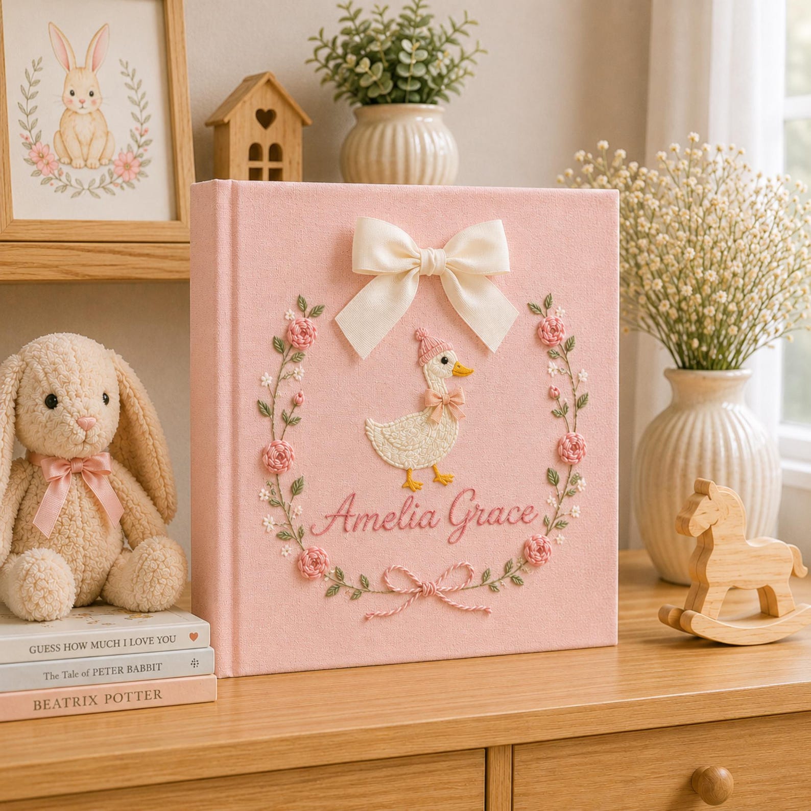 Personalized pink hand embroidered baby photo album with duckling, floral wreath, and ribbon bow