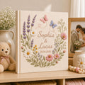 Custom botanical embroidered wedding photo albums with lavender flowers, butterflies, ribbon bows, and personalized couple names on linen covers