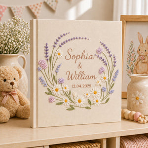 Custom lavender floral embroidered wedding photo albums with pastel botanical wreaths, daisy flowers, and personalized couple names on linen covers