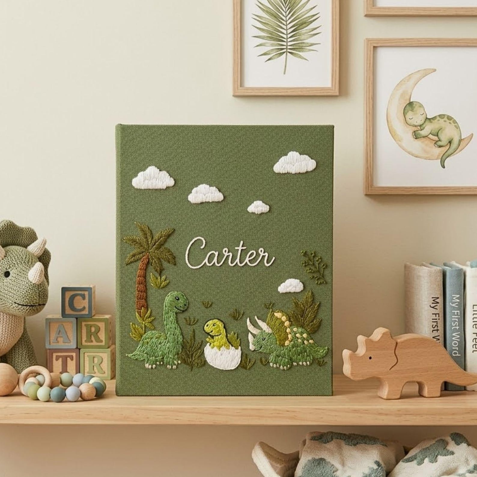 Personalized dinosaur hand embroidered baby photo album with cute prehistoric nursery design on green linen cover