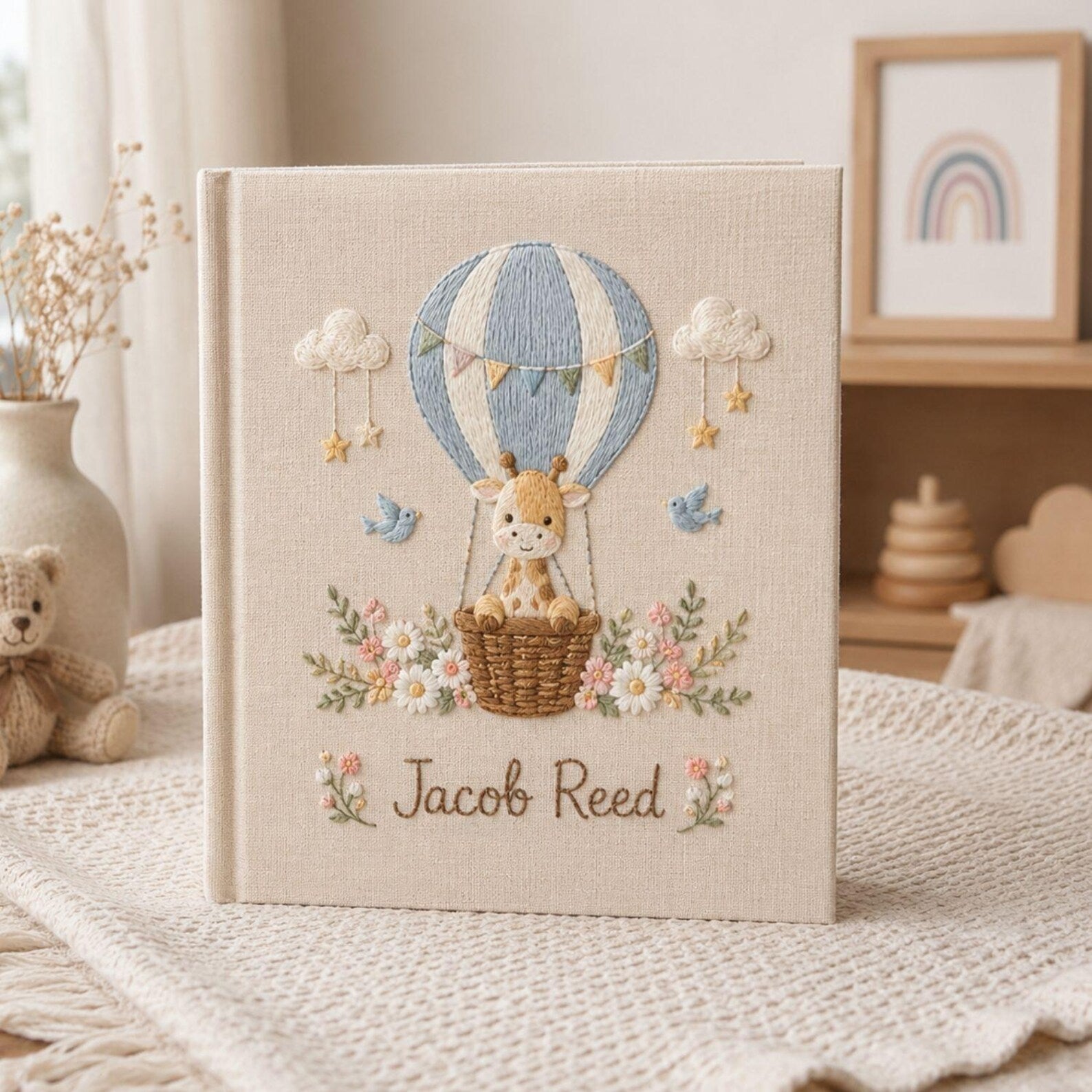 Personalized hand embroidered photo album featuring a baby giraffe in a hot air balloon with flowers clouds birds and custom name embroidery