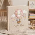 Personalized hand embroidered photo album featuring an elephant and bunny in a pastel hot air balloon with hanging hearts and custom name embroidery