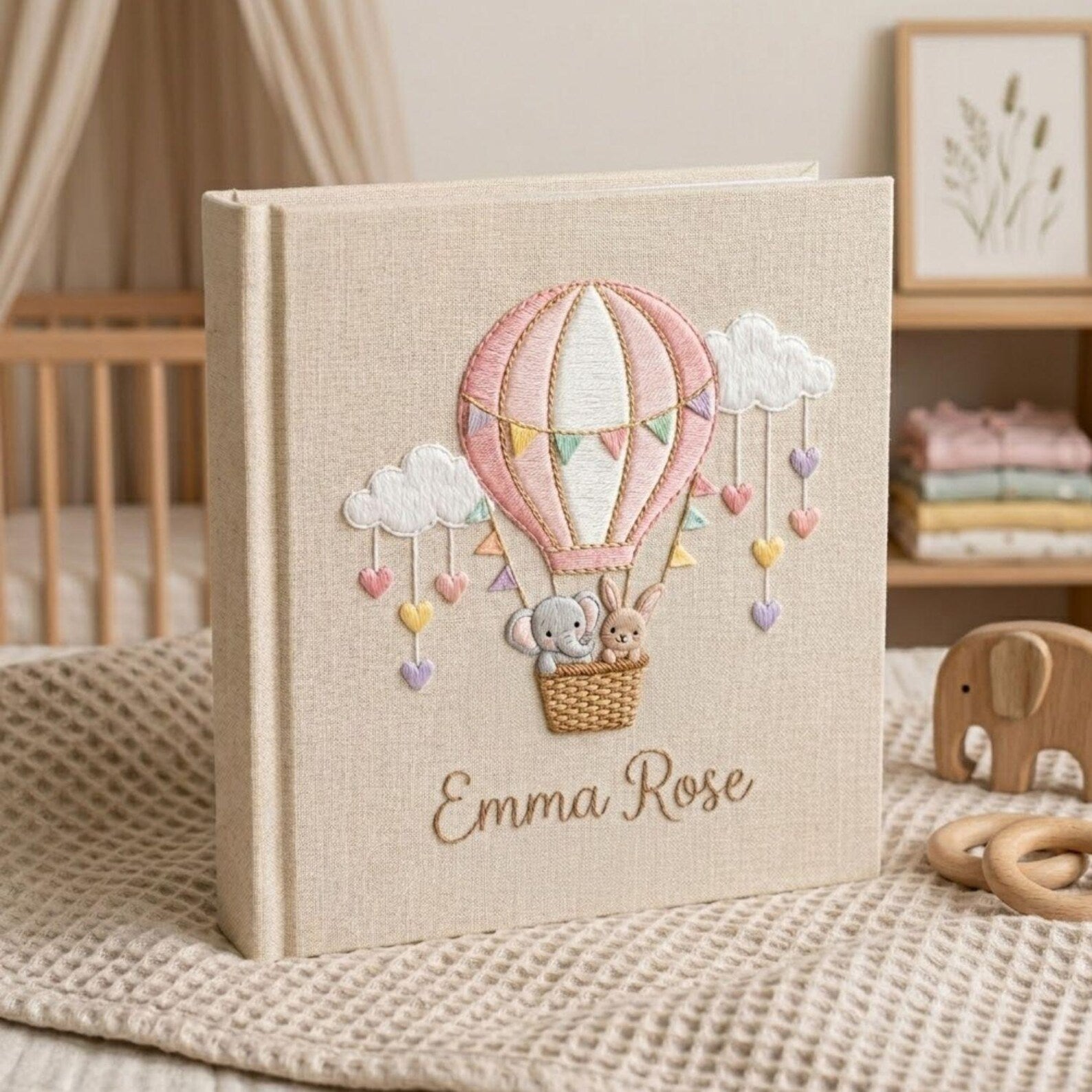 Personalized hand embroidered photo album featuring an elephant and bunny in a pastel hot air balloon with hanging hearts and custom name embroidery
