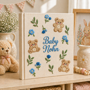 Personalized hand embroidered photo album featuring teddy bears, botanical flowers, leafy accents and custom baby name embroidery on a linen cover